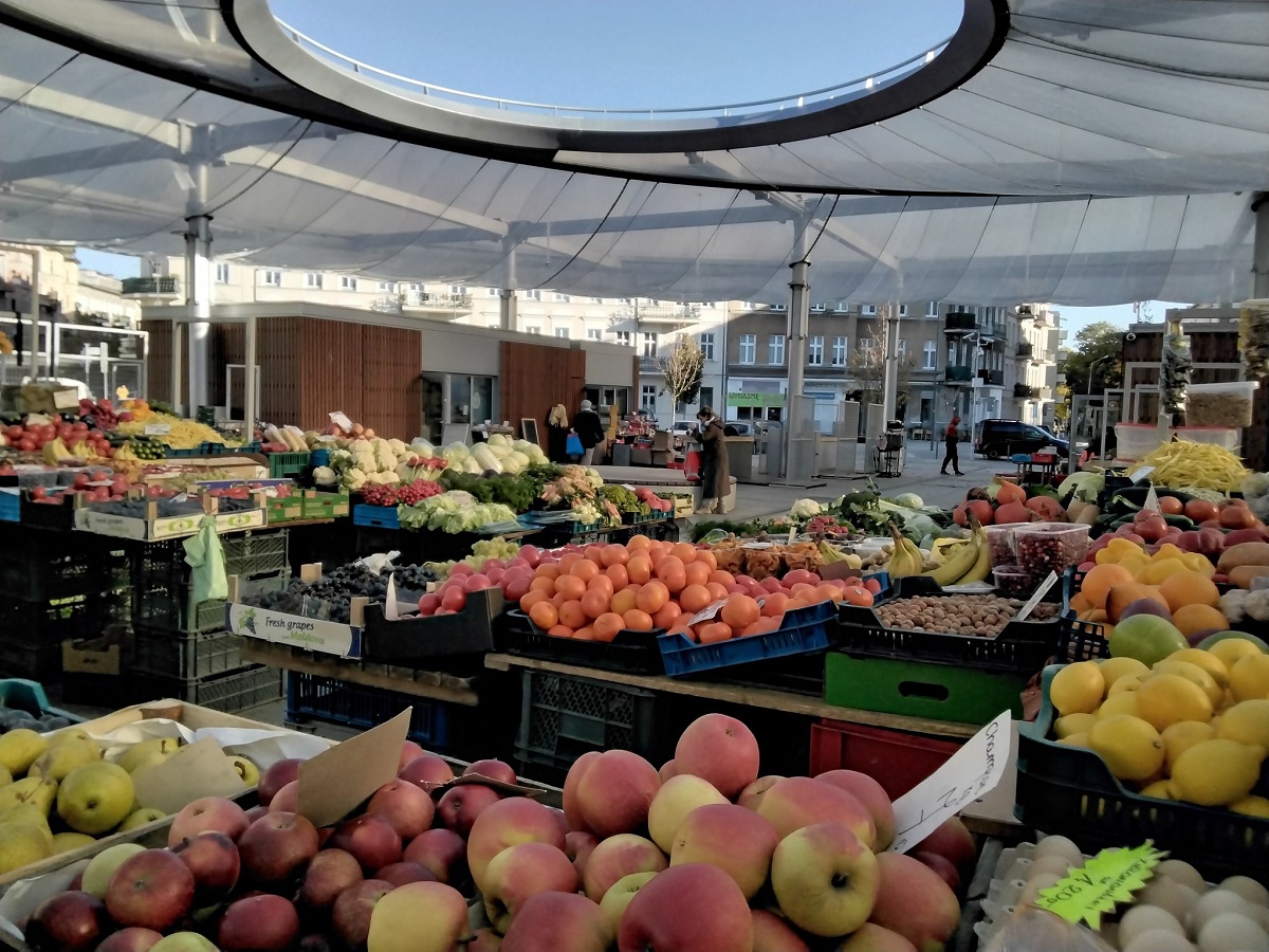 targowisko na ryneczku, zadaszone, widać stragany z owocami i warzywami